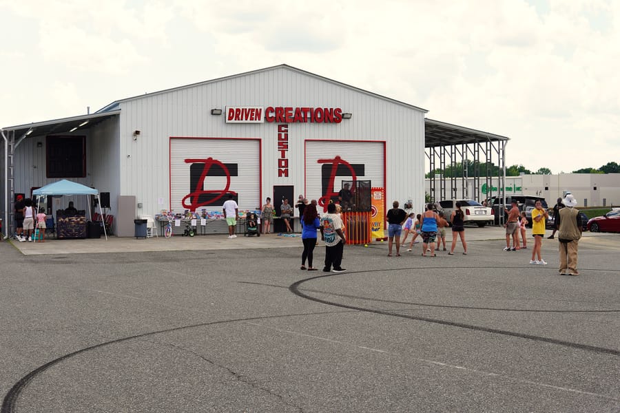 The Eats on 601 lot on Summer Kickoff day, food trucks lined up under a blue sky at Driven Creations Custom